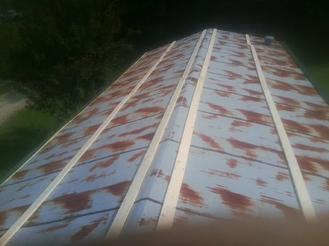 Rusted metal roof panels with new wood purlins before replacement — Storm Damage Roof Repair in Onamia by Roofing Brothers