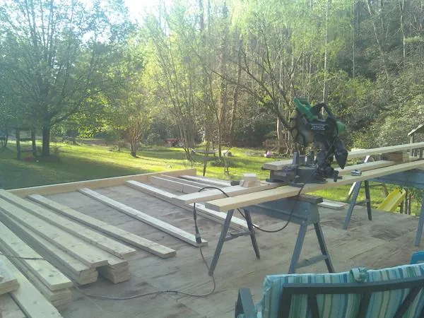 Miter saw and framing lumber on a deck under construction in Onamia