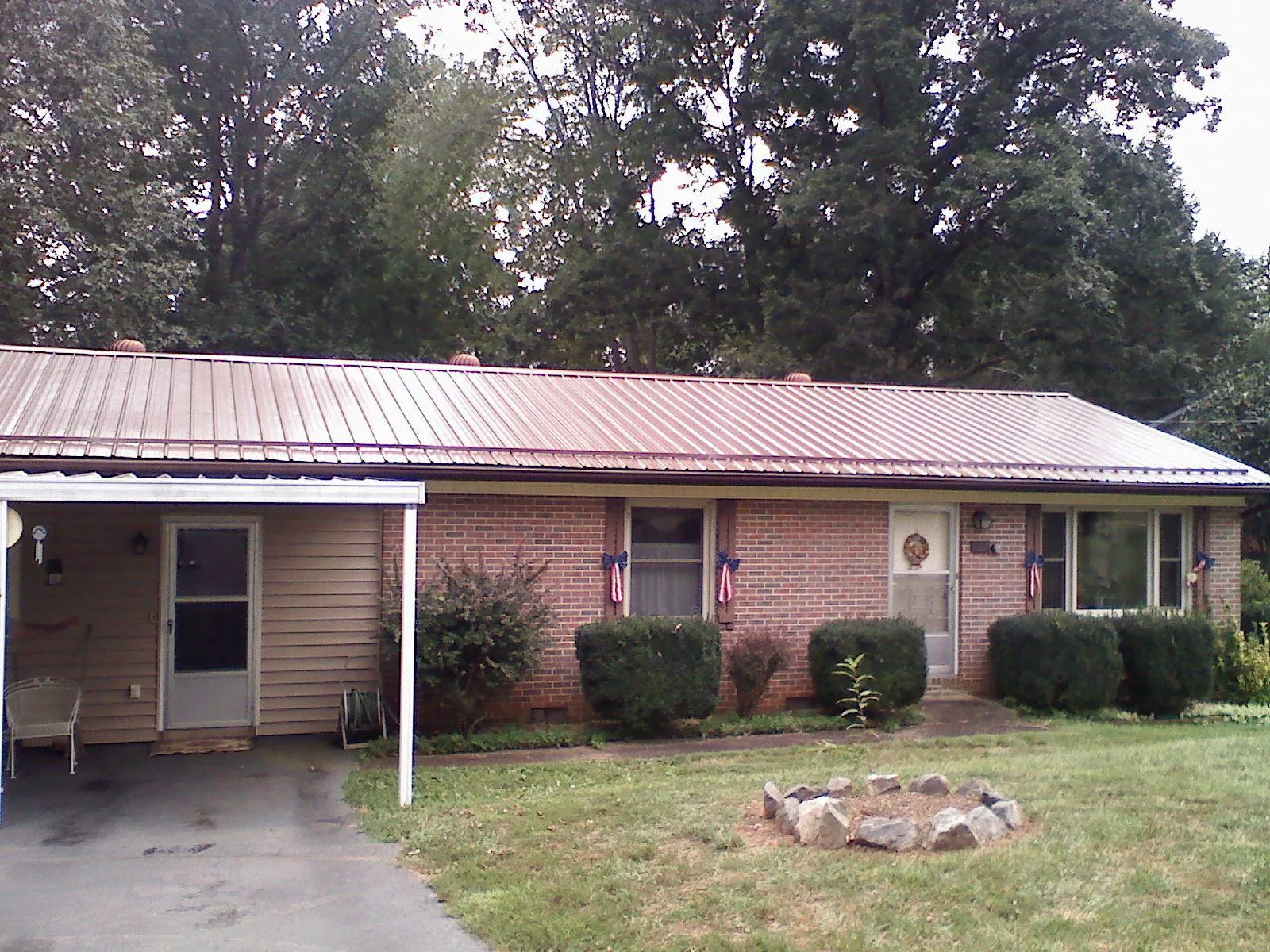 Bronze metal roof and carport on a brick ranch home — Roof Repair work by our crew in Onamia