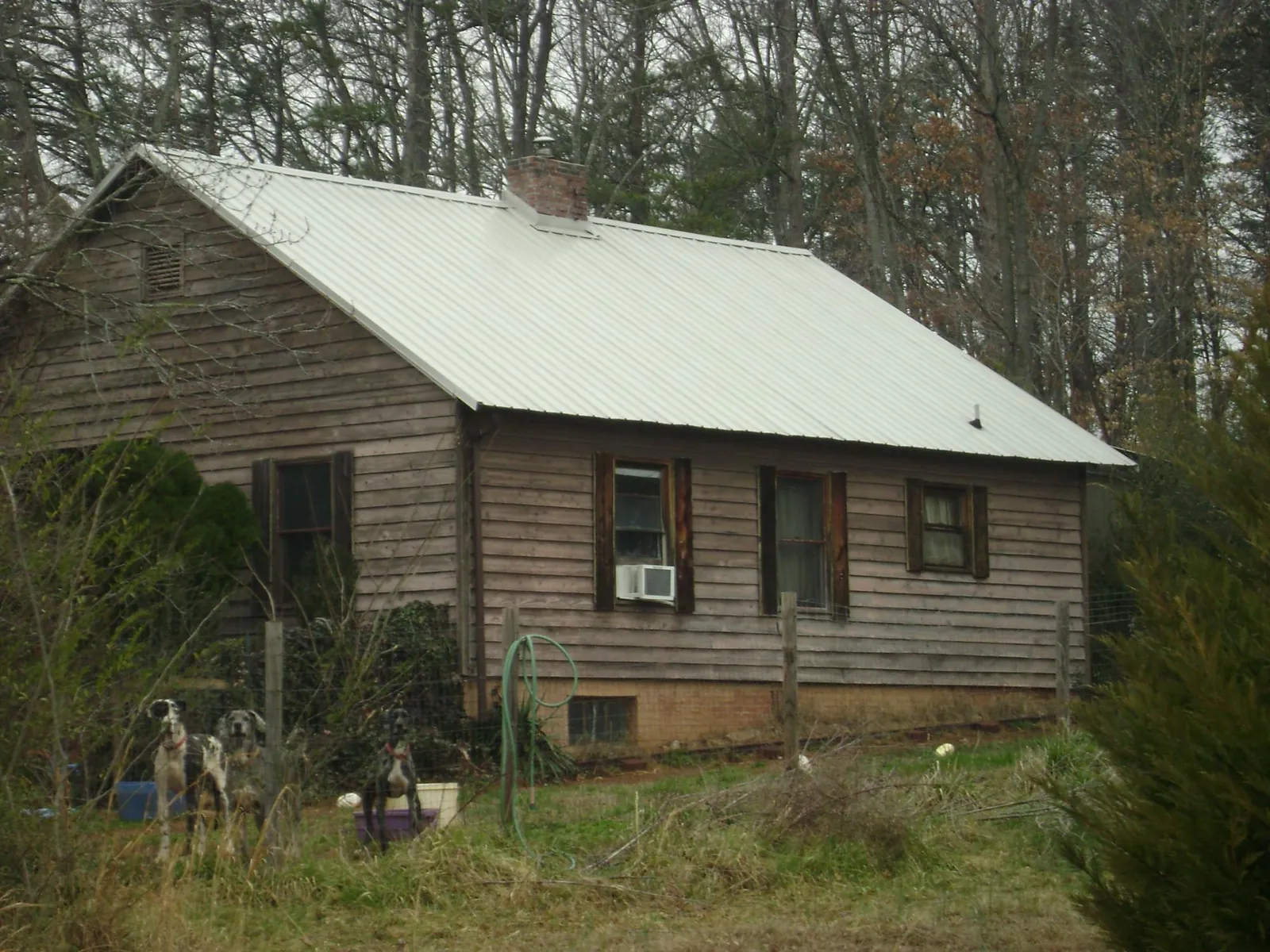 White metal roof on an old wood sided farmhouse, from a Metal Roof Installation job in Onamia